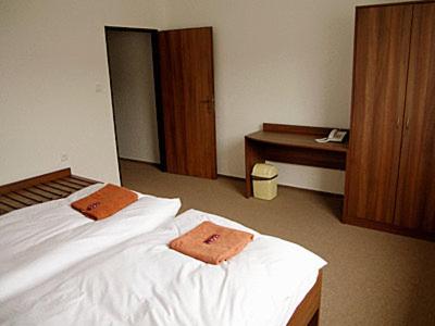 a bedroom with a bed with two towels on it at Penzión* ADONAI SLOVAKIA in Banská Bystrica