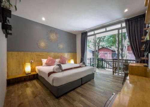 a bedroom with a bed and a large window at Pico Samui in Bophut