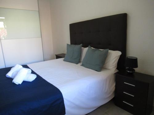 een slaapkamer met een groot wit bed met blauwe kussens bij Garden Relax Apartments, by Comfortable Luxury in Corralejo