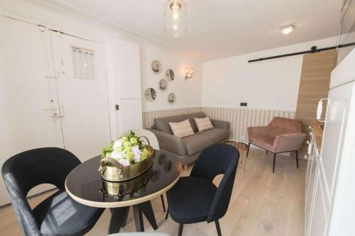 un salon avec une table, des chaises et un canapé dans l'établissement Leocadia, à Paris
