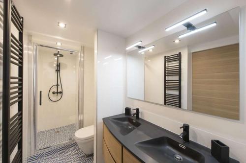 une salle de bain avec un lavabo, des toilettes et un miroir dans l'établissement Leocadia, à Paris