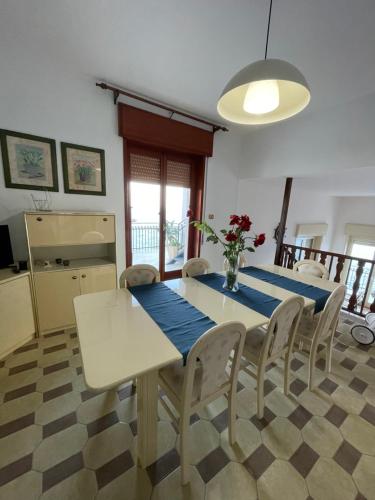 a dining room with a blue table and chairs at La Timpa in Acireale