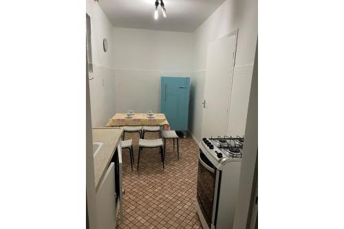 uma pequena cozinha com uma mesa e uma cozinha com uma mesa e cadeiras em Apartamento confortável na praça central em Águas de Lindoia