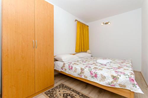um quarto com uma cama e um armário de madeira em Apartment Ane em Split