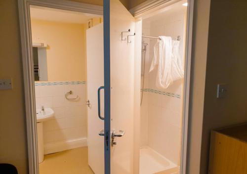 a bathroom with a shower and a sink at Glendalough International Youth Hostel in Laragh