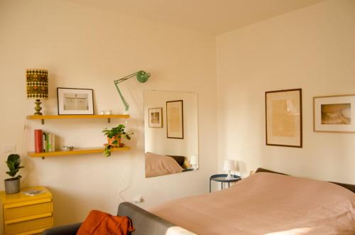 1 dormitorio con cama y espejo en Monolocale in villa, a 300 metri dal centro - Beau Rivage room apartment, en Santarcangelo di Romagna