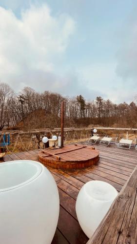 a wooden deck with white chairs and tables on it at Casa cu Prispa in Sighişoara
