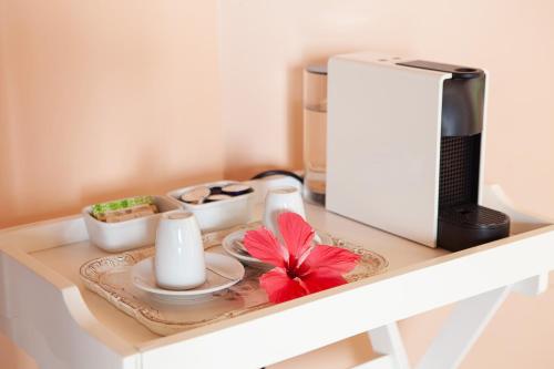 a table with a coffee maker and a plate with a flower on it at Pousada Mangabeiras in Ilha de Boipeba