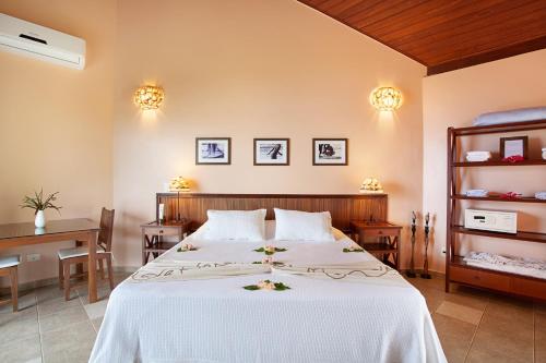 a bedroom with a large white bed with flowers on it at Pousada Mangabeiras in Ilha de Boipeba