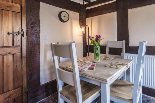 - une table à manger avec un vase de fleurs dans l'établissement River Cottage, Melverley, à Melverley