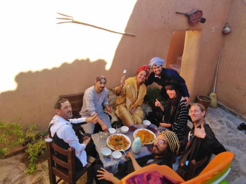 a group of people sitting around a table at Maison d'hôte sirwaji in Assa