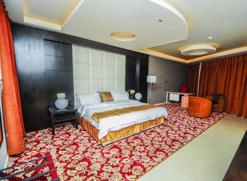 a bedroom with a bed and a large red rug at Zievle Executive Apartments in Buraydah