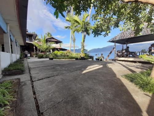 a walkway next to a building with a view of the ocean at Beach Guest House in Maninjau