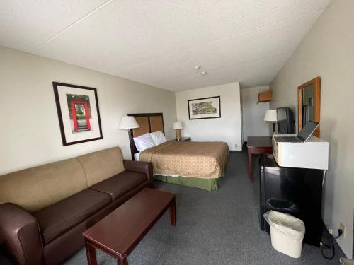 a hotel room with a bed and a couch at Heritage Inn & Suites in Niagara Falls