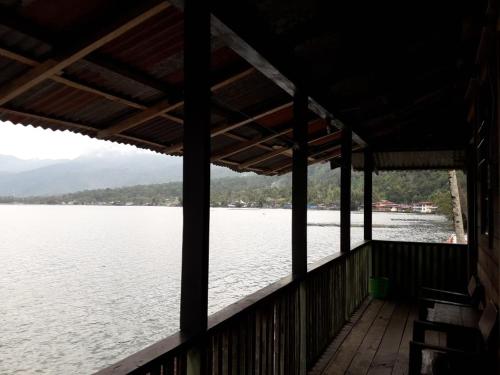a view from the porch of a house overlooking the water at Beach Guest House in Maninjau