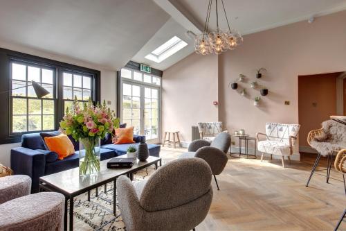 a living room with a blue couch and chairs at The Railway Hotel by Barefoot Retreats in Burnham Market
