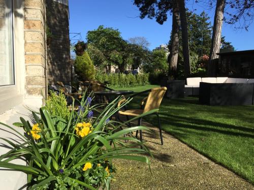 伯恩茅斯的住宿－Applewood Hotel，庭院里种着椅子和鲜花的花园