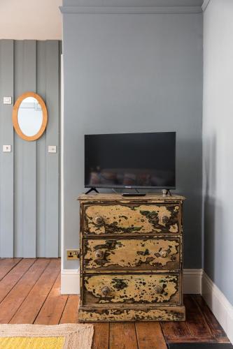 a dresser with a television on top of it in a room at Severnside Press BnB in Newnham