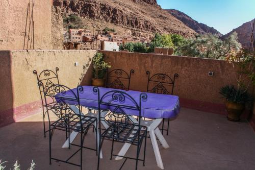 a purple table and chairs on a balcony at Kasbah Maison D’hôte Lalla Zahra in Aït Baha