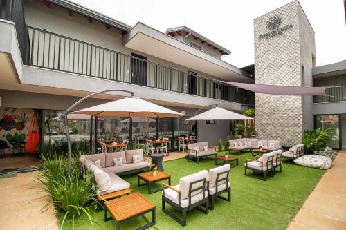 an outdoor patio with tables and chairs and umbrellas at Pousada Flores do Carmo in Pirenópolis