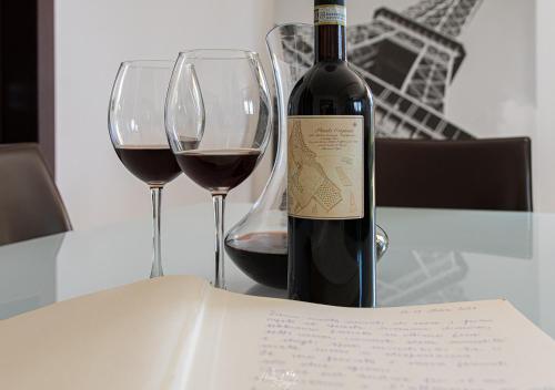 a bottle of wine and two wine glasses on a table at Villa in Langa in Belvedere Langhe