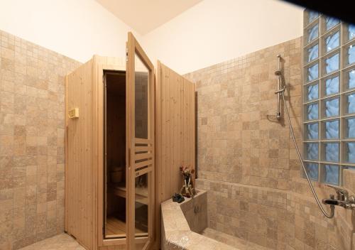 a shower with a wooden door in a bathroom at Villa in Langa in Belvedere Langhe
