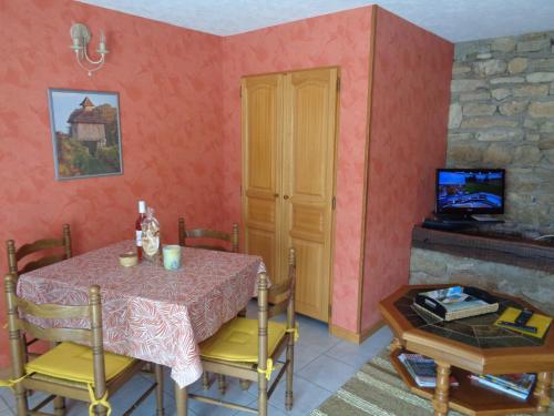 une salle à manger avec une table et une télévision dans l'établissement Les dessous de la grange, à Larroque-Toirac