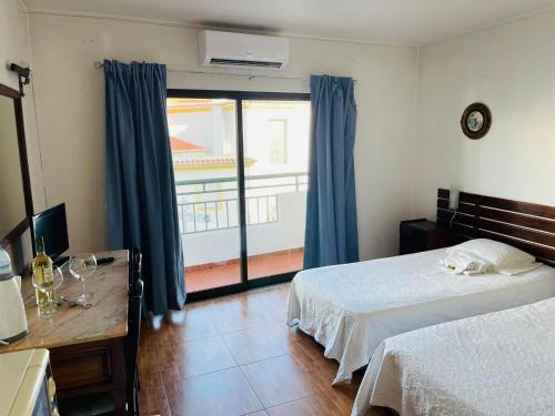 a bedroom with a bed and a large window at Casa Do Canto in Albufeira