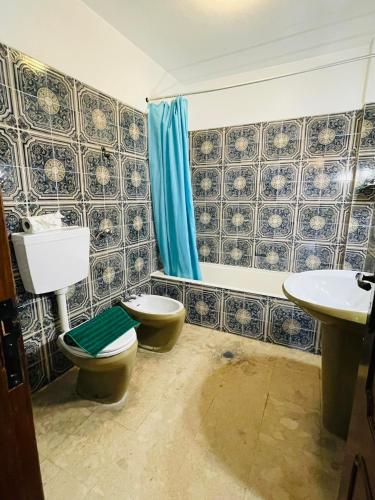 a bathroom with a toilet and a sink at Casa do Canto in Albufeira