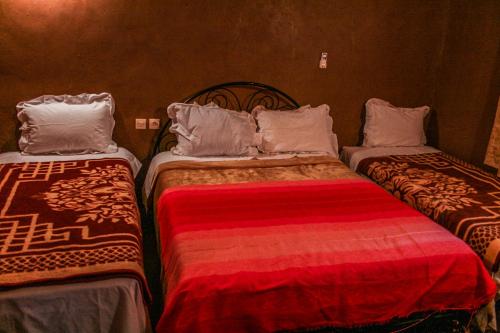 two beds sitting next to each other in a room at Kasbah Maison D’hôte Lalla Zahra in Aït Baha