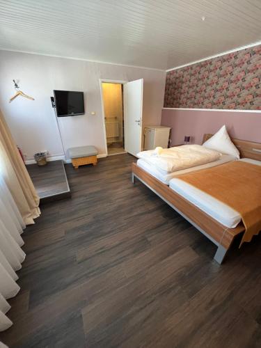 a bedroom with a large bed and a television at Gästehaus Geli in Heide