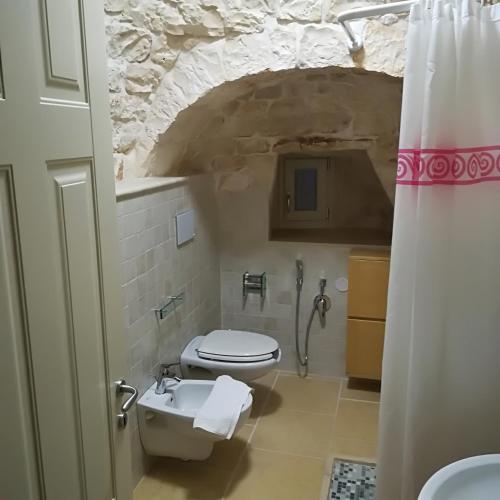 a bathroom with a toilet and a sink at Trulli Manuela 2 in Locorotondo