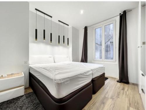 Un dormitorio blanco con una cama grande y una ventana. en Appartement Palais des Festivals, en Cannes