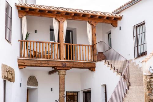 un balcón de madera en el lateral de un edificio con escaleras en Casa Platón Páramo, en Oropesa