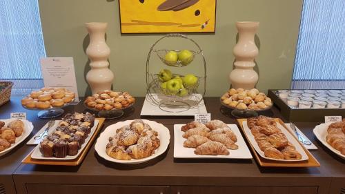 a table with many different types of pastries on it at Hotel Europa Art Caserta in Caserta
