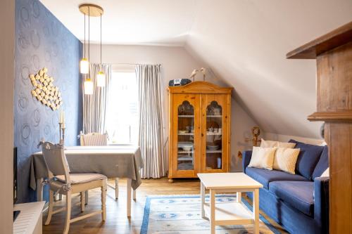 ein Wohnzimmer mit einem blauen Sofa und einem Tisch in der Unterkunft Alt Wyk in Wyk auf Föhr