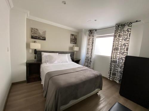 um quarto com uma cama grande e uma janela em Hotel Picasso Inn em Bogotá