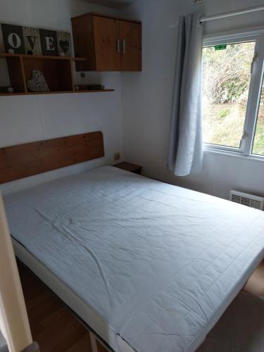 Cama en habitación pequeña con ventana en Bungalow 4 voire 6 personnes BRAY DUNES à 300 mètres de la plage, en Bray-Dunes