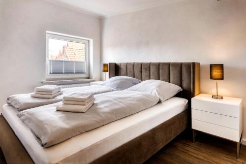 - une chambre avec un grand lit et des serviettes dans l'établissement Zwischen Eider und Treene, à Friedrichstadt