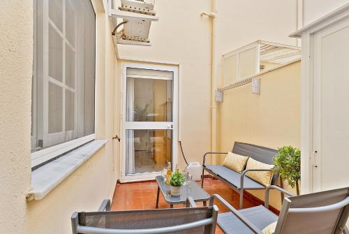 a balcony with chairs and a table and a window at Apartamento con patio a 1 minuto de la playa in Fuengirola