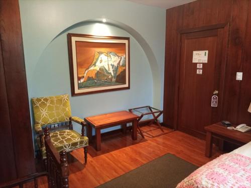 a room with a bed and a table and a chair at Hotel Victoria in Cuenca