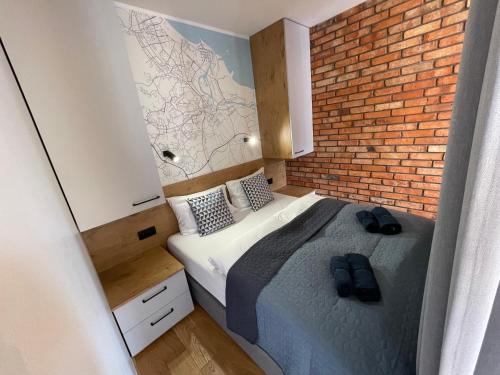 a bedroom with a bed with a brick wall at RAJSKA BRAMA in Gdańsk