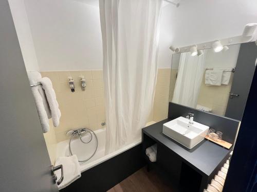 a bathroom with a sink and a shower at Hôtel Restaurant La Buffe in Autrans