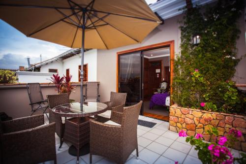a patio with a table and chairs and an umbrella at Hotel Victoria in Cuenca