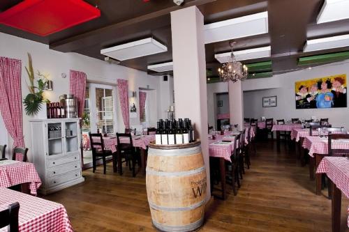 uma sala de jantar com mesas e cadeiras e um barril de vinho em Vakantiewoningen-Pizzeria Blanckthys Voeren em Voeren