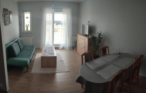 un soggiorno con tavolo e divano verde di Apartament Północna a Brodnica