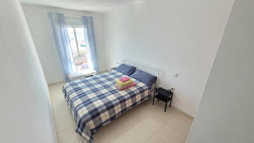 mała sypialnia z łóżkiem i oknem w obiekcie Amazing ocean view apartment w Corralejo
