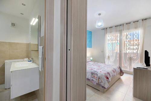 1 dormitorio con cama, lavabo y ventana en Appartamento Shanaia, en Loano
