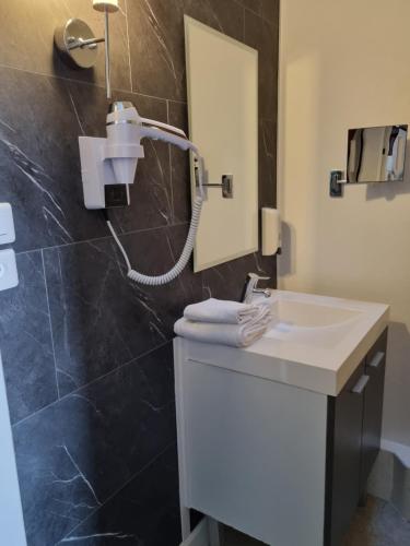 a bathroom with a sink and a shower at Hotel du Cheval Blanc in Cerizay