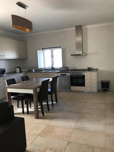 a kitchen with a wooden table and chairs in a room at Moradia Gémea em Herdade Santa Marta in Zebreira